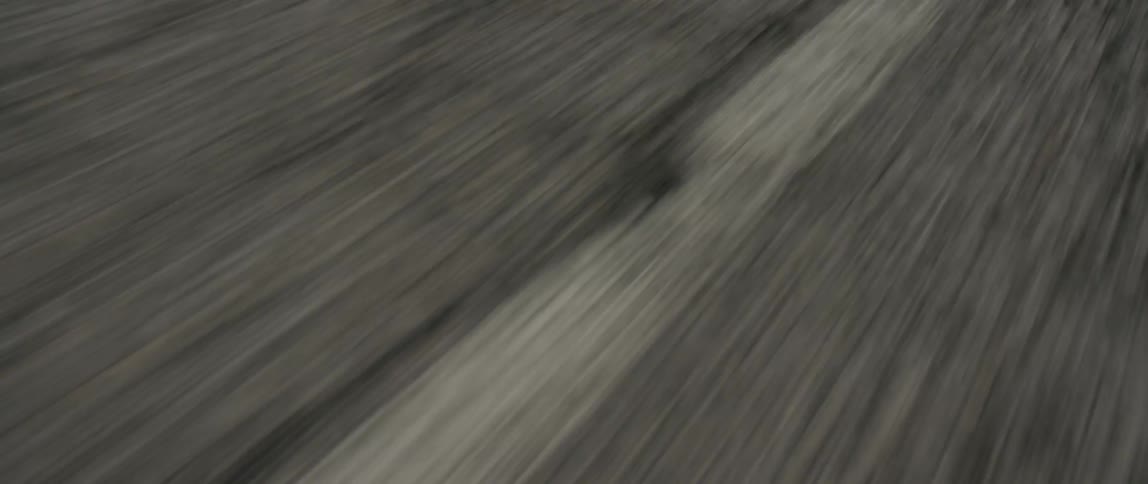 White road markers on the asphalt are passed by at speed