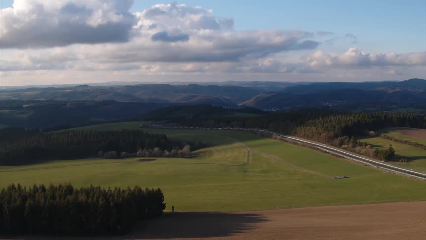 The fields ahead are vast with a railroad on the side