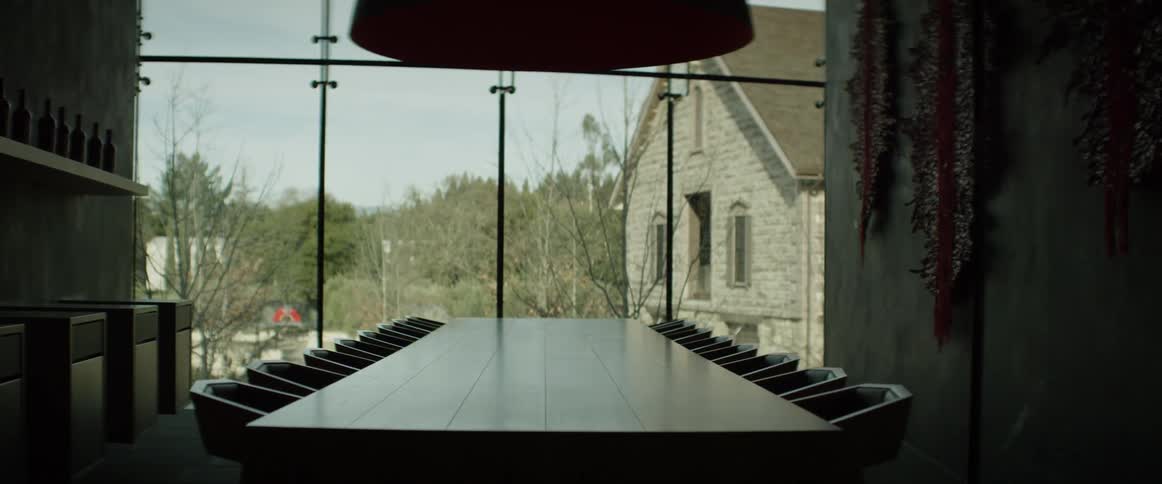 A conference table is sitting empty in front of a window