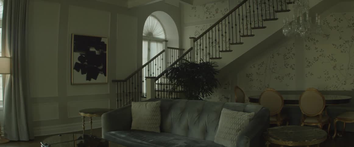 An empty living room at the base of a staircase
