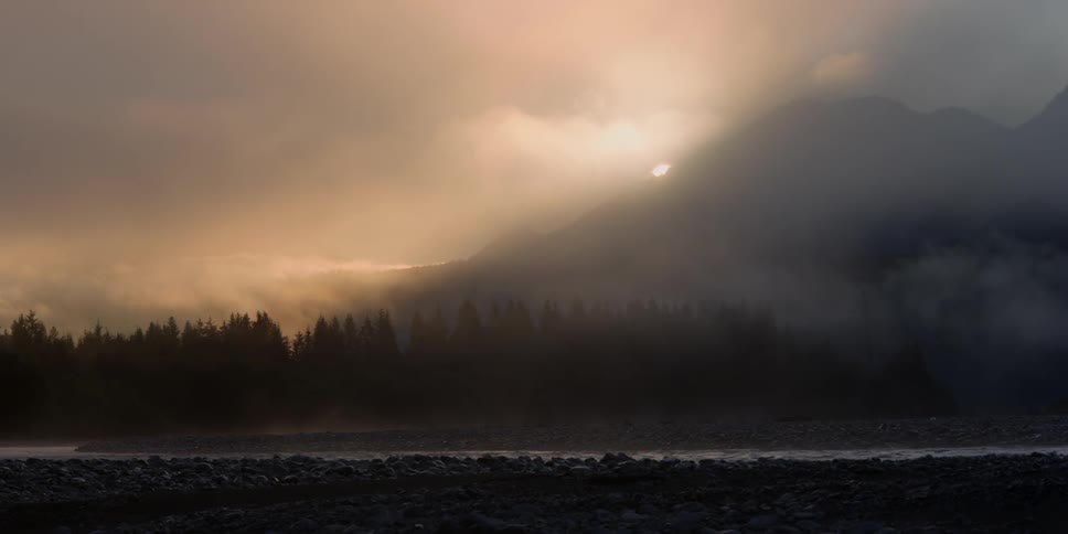 A foggy mountain side is being filmed from a distance