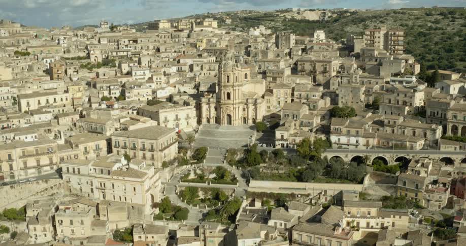 A cathedral sits amidst an old city on a hillside