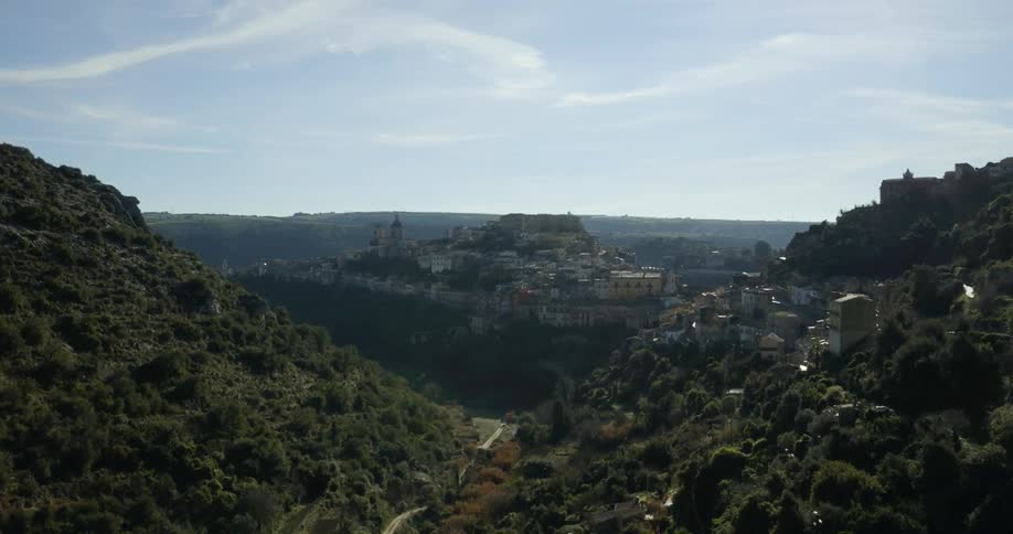 Buildings and home cling to the sides of a plateau and hills