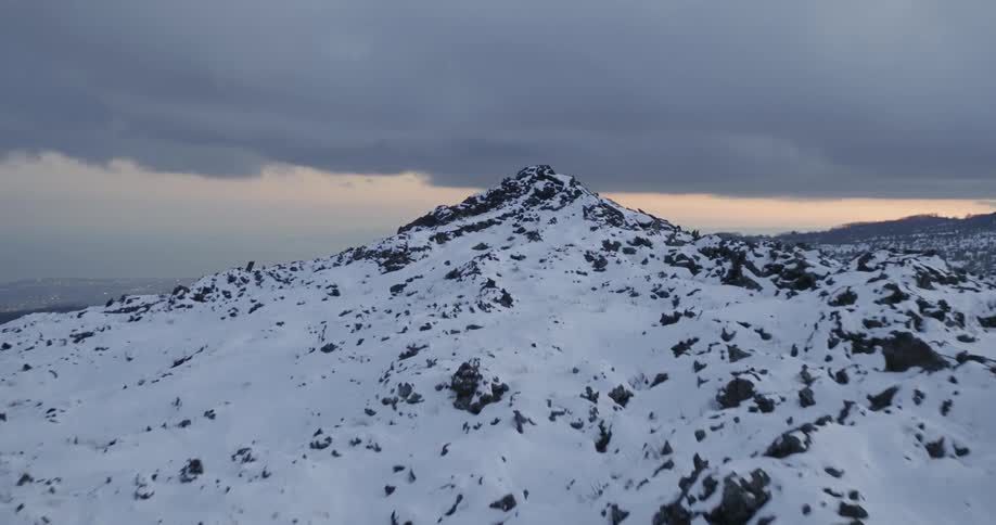 Dark clouds hover over snow-covered mountain peaks