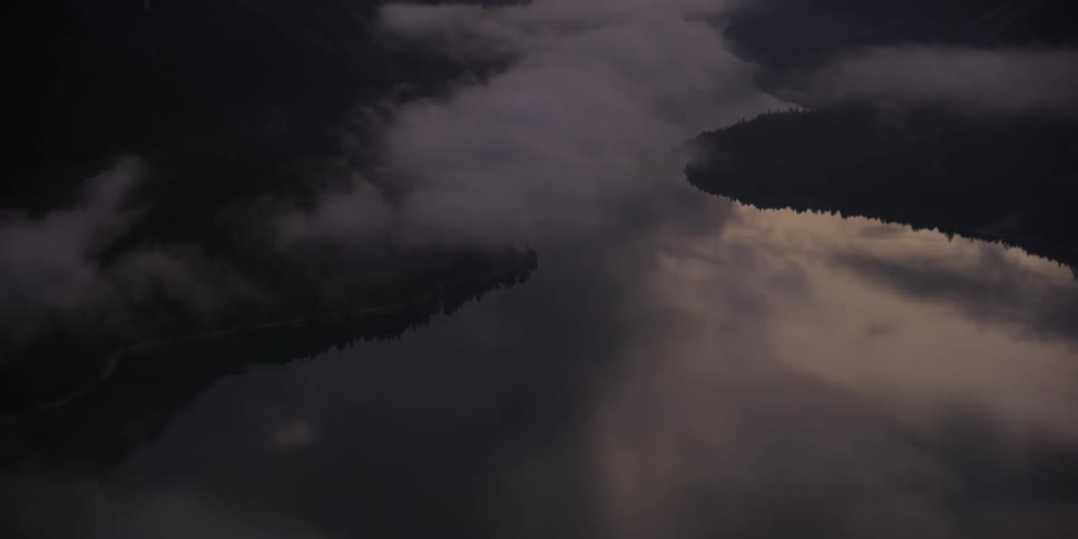 A foggy valley is filmed from a drone