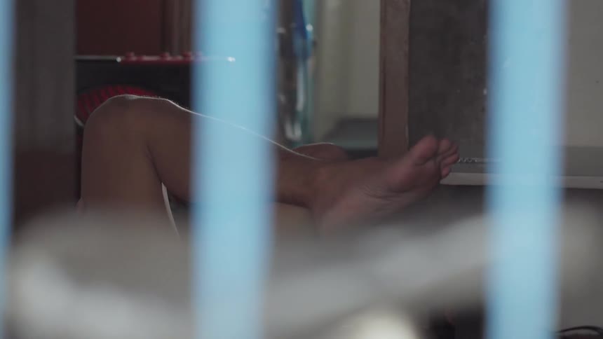 Person with a bare foot reclines with his leg crossed
