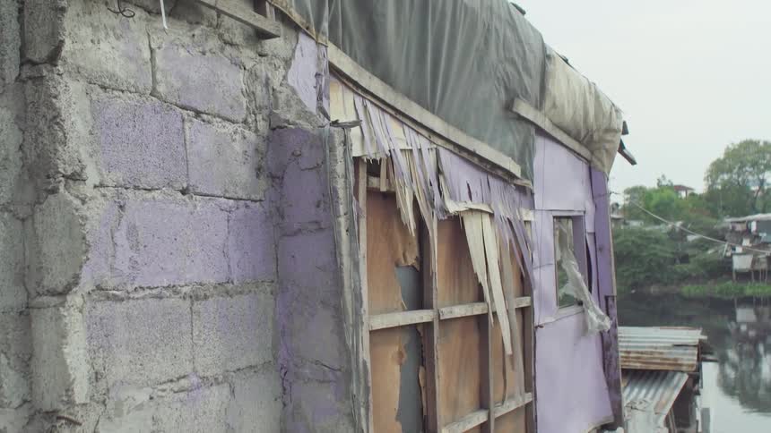 Tarp hangs off a tattered building