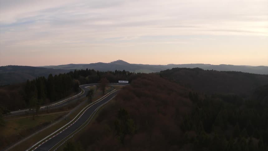 A road winds through a forest on a rural hilltop