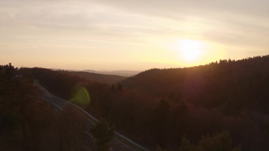 Sunrise behind a hill in the forest