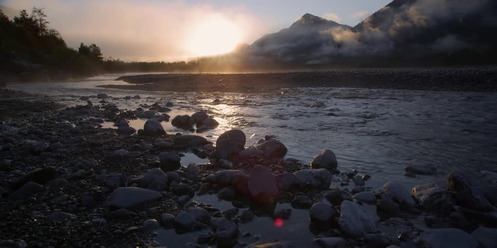 Water flows as the sun shines on a stream