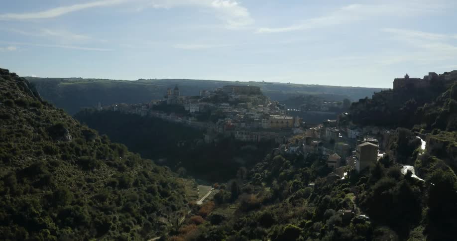 A town on a hillside is filmed from a drone