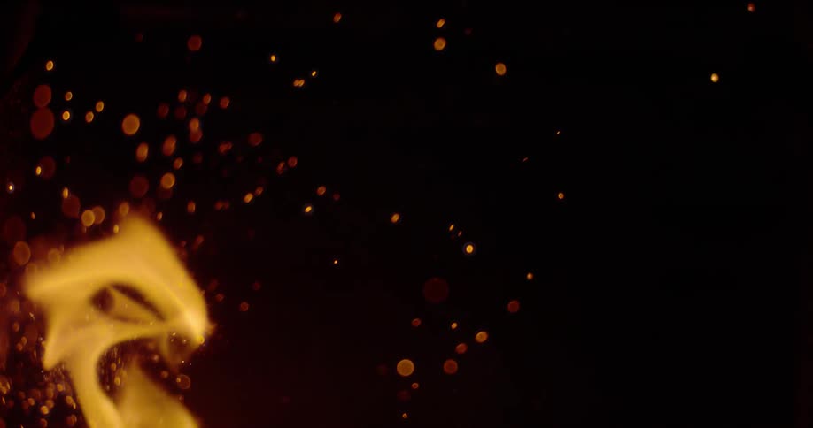 The flames of a fire burn and casts sparks