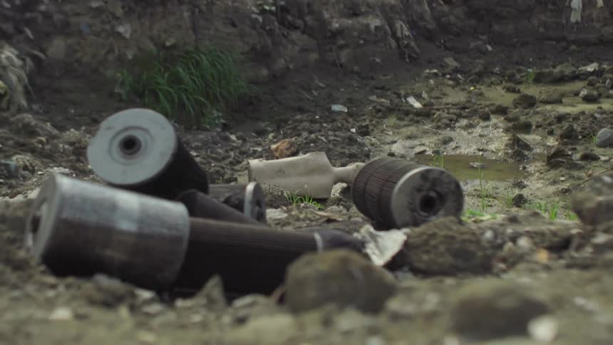 Discarded cylinders sit on the stones