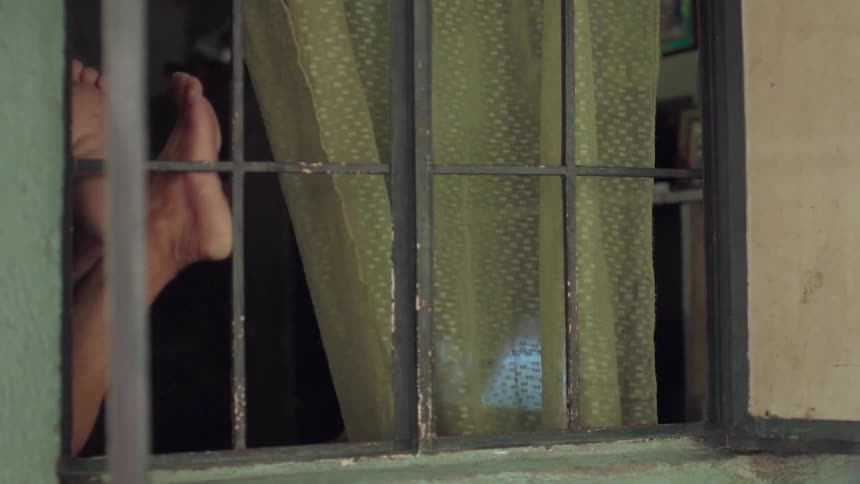 A person's feet are pressed against a window