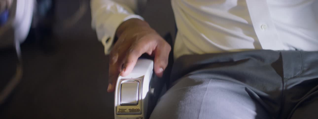 A nervous man grips the arm of a plane seat