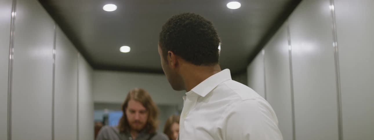 A man looks back at other people in a hallway