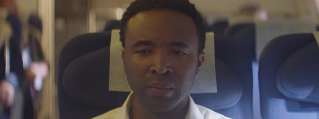 A man sits fearfully in a rocking airplane seat