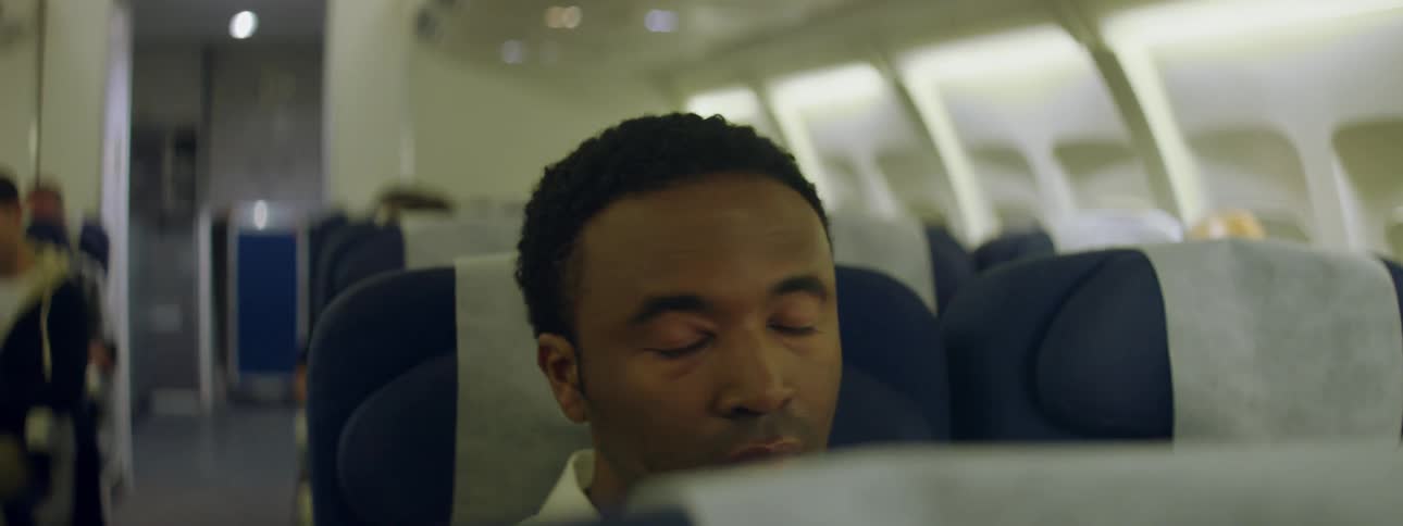 A man sits anxiously in an airplane seat