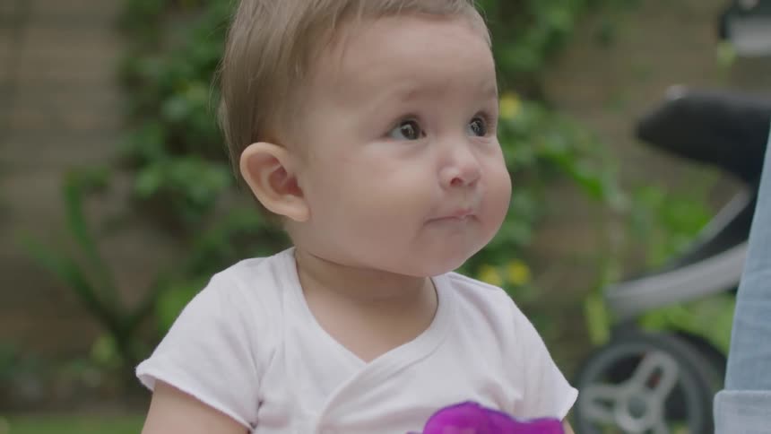 A baby grabs a teething toy