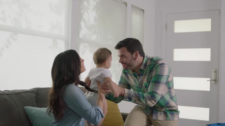 A man is walking into a home and picking up a baby