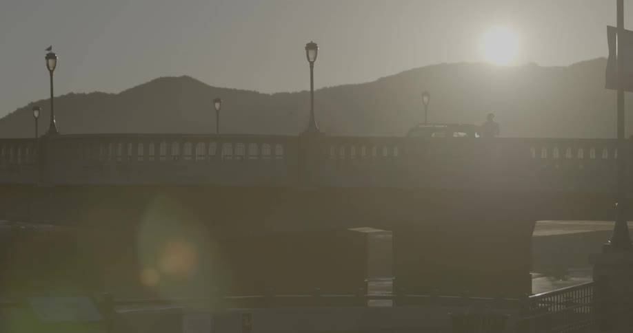 A person jogs over a bridge in the daytime