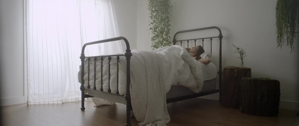 A woman in bed in a white room