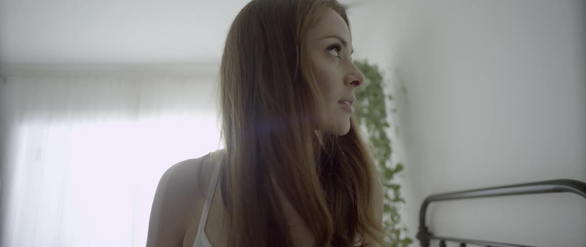 Woman with long brown hair looks around the room