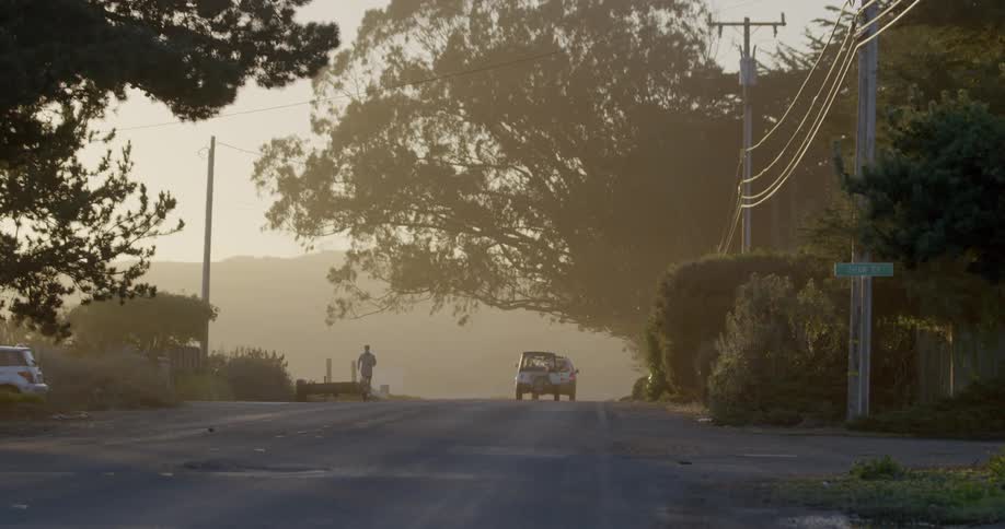 A man is jogging down the road