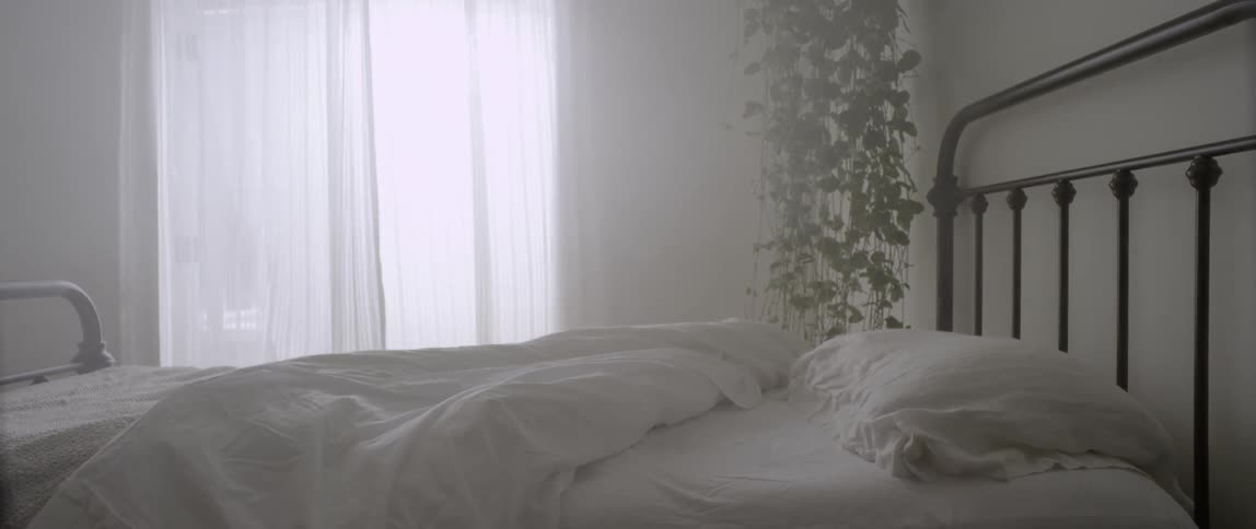 Wind blows the white curtains of a bedroom