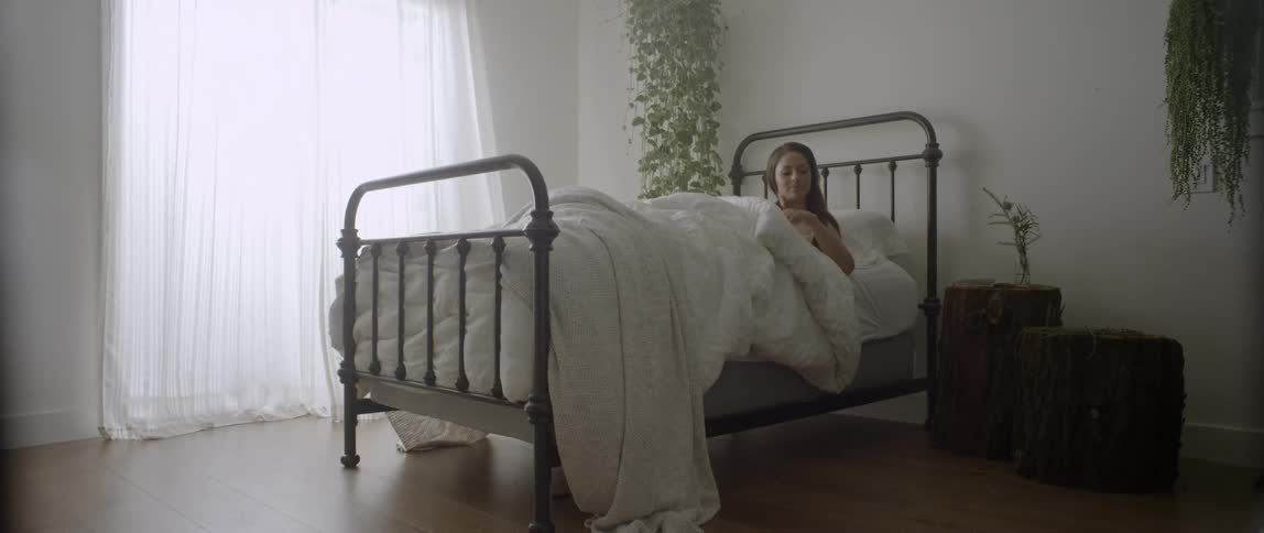 A woman sits up in bed