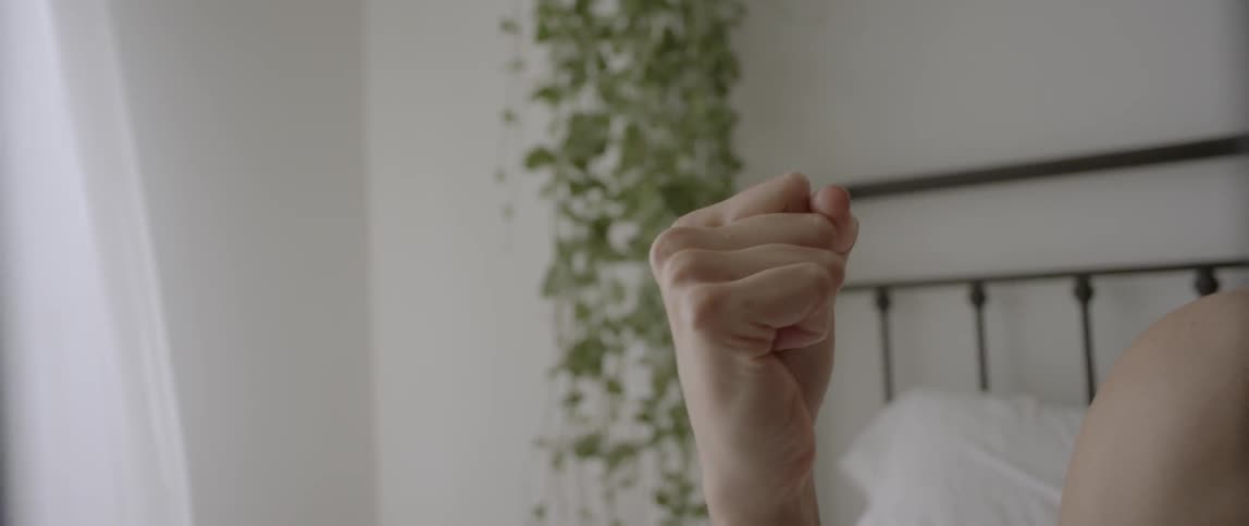 A woman smiles as she opens and closes her hand