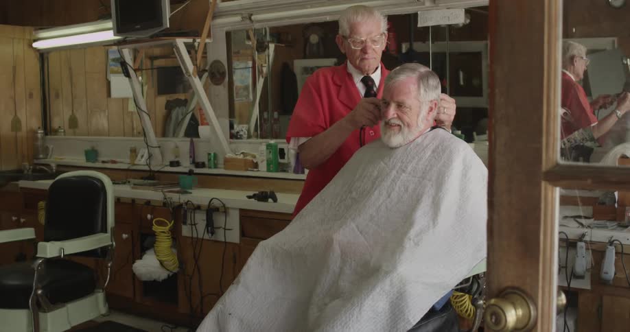 Barber giving a senior man a haircut