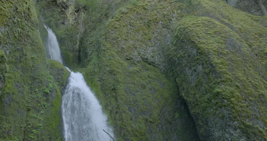 Water from the waterfall flowing down the green rocks