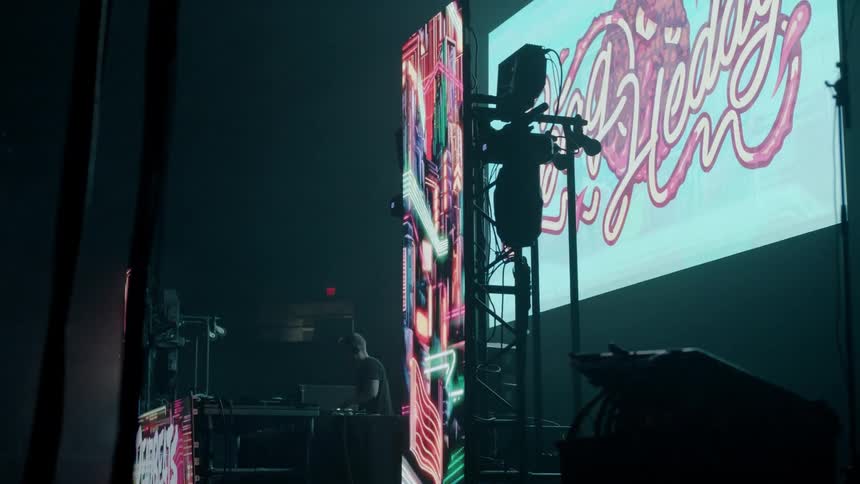 A dj is playing a show in front of an audience