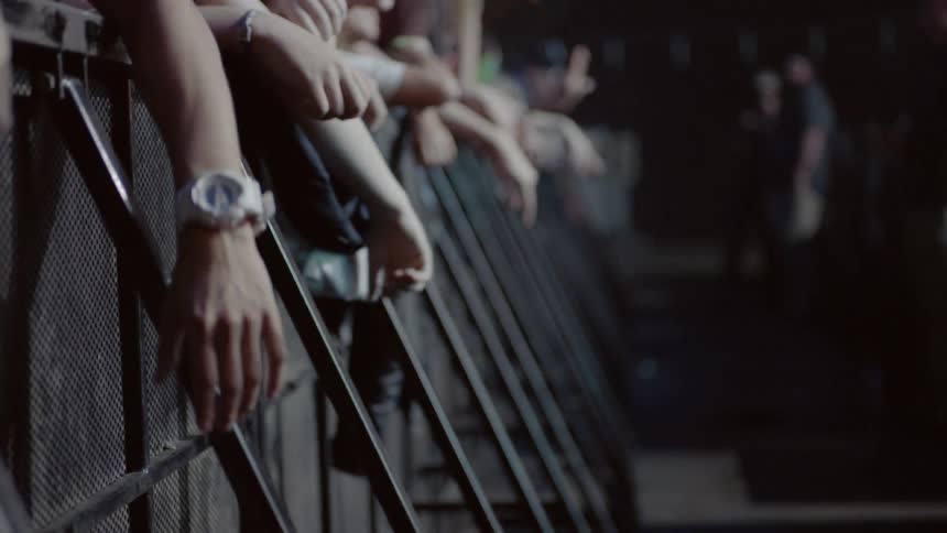 People dancing against a railing at a concert