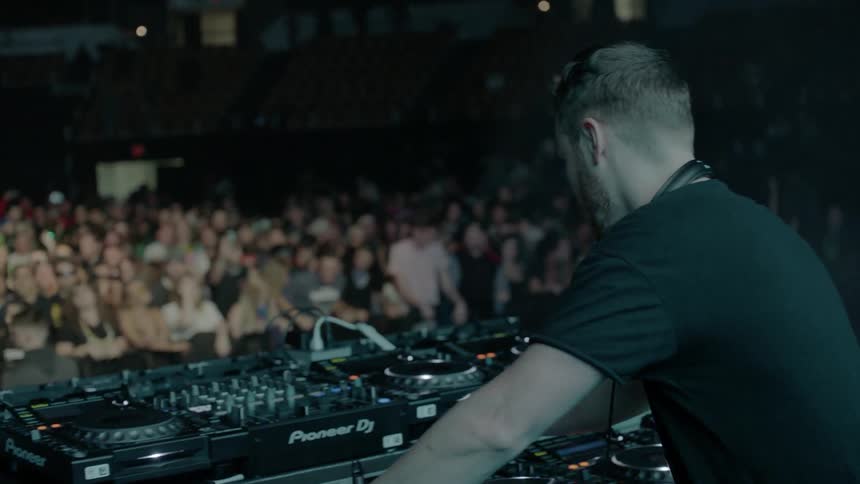 A dj performs for an audience