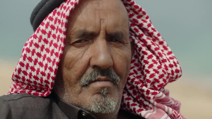 A man with a mustache is sitting