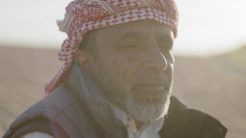 A bearded man in the desert blinks