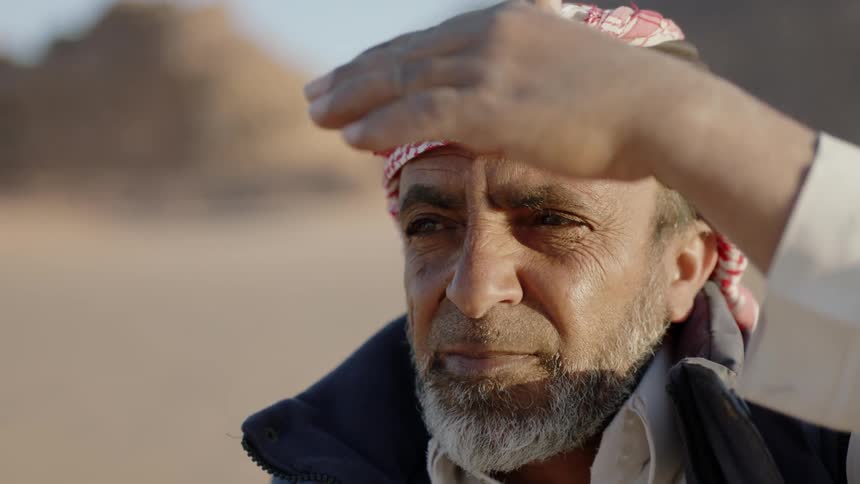 A man shields his eyes from the sun