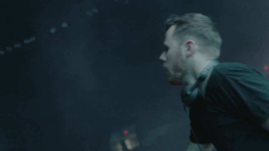 A dj is playing in front of a crowd