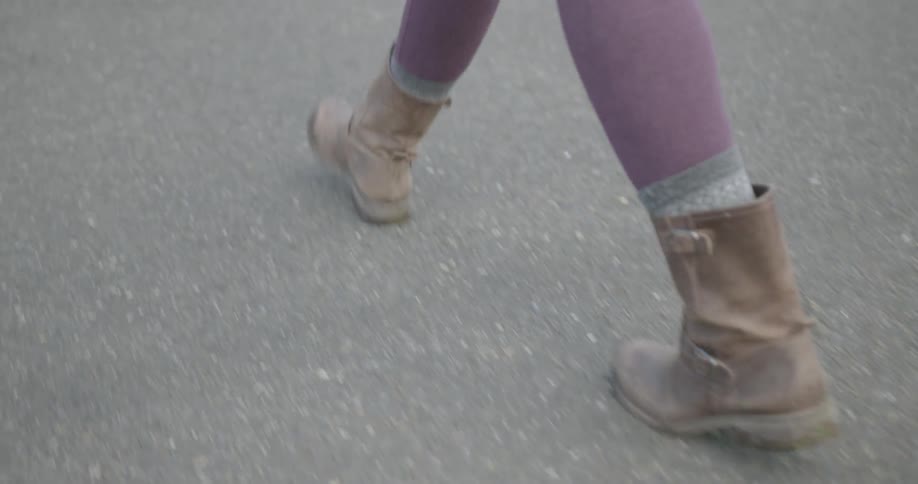 A woman walks across the asphalt