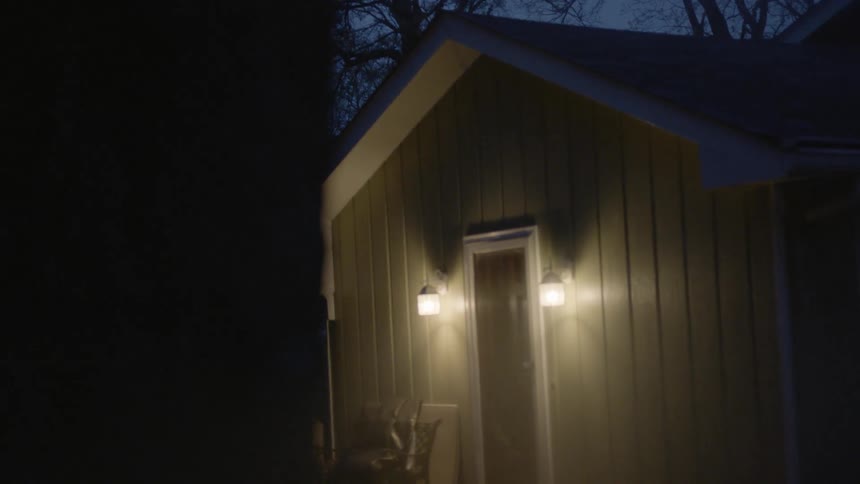 Lights illuminate the door of a house