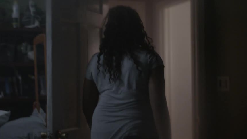 A woman steps out of bed and walks out the door