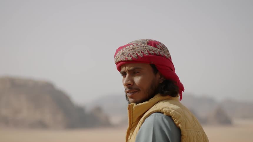 A man slowly turns around in the desert