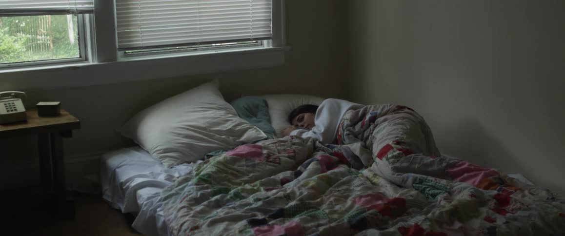 A woman is laying in bed covered up