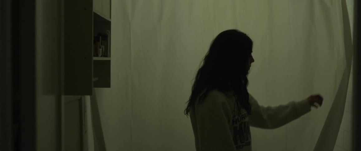 A woman closes a curtain