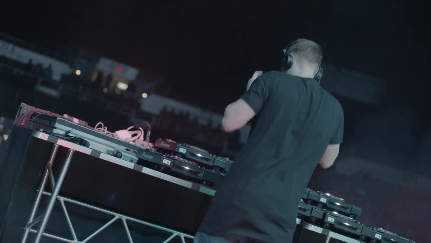 Man puts on headphones then adjusts the sound equipment