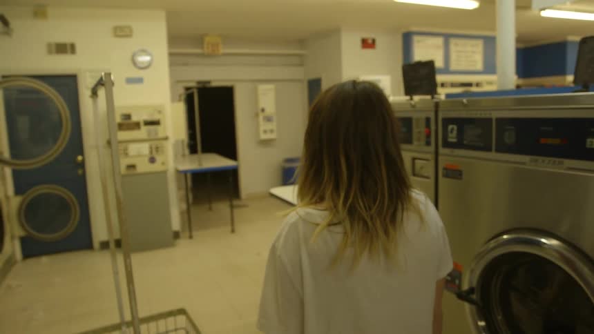 A woman walks into a laundromat
