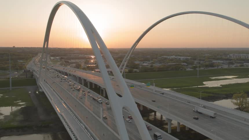 Traffic bunches up as it crosses a bridge at dawn