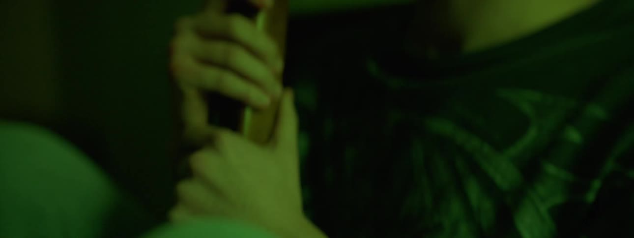 A young man grips a rifle as lights strobe